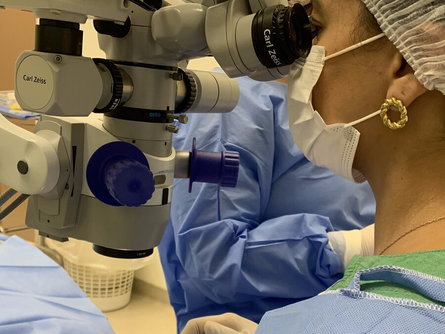 Dra. Mayra Fagundes ao microscópio cirúrgico Carl Zeiss durante cirurgia de catarata
